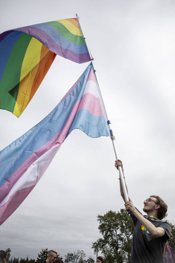 Jack Schrantz waves flags during the Stanwood-Camano Pride event at Freedom Park in Camano, Washington on Saturday, June 1, 2024. (Annie Barker / The Herald)

