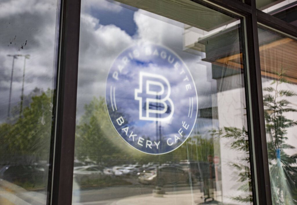 A Paris Baguette sign is visible through a window at the new store next to Alderwood Mall on Thursday, May 30, 2024 in Lynnwood, Washington. (Olivia Vanni / The Herald)

