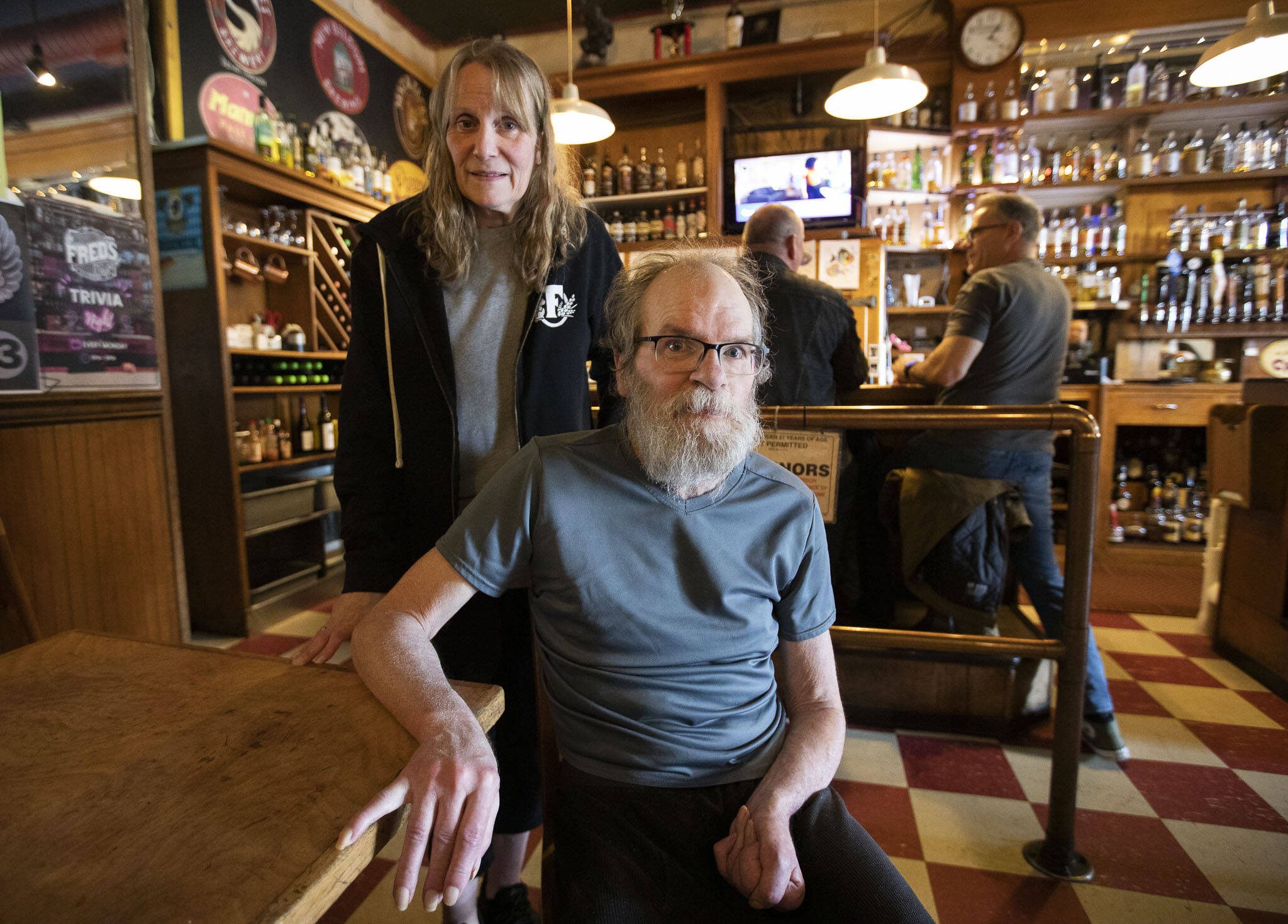 Fred’s Rivertown Alehouse owners Mark “Chewey” and Ginger Nuss at the “staff table” inside the pub on Tuesday, June 4, 2024 in Snohomish, Washington. (Olivia Vanni / The Herald)