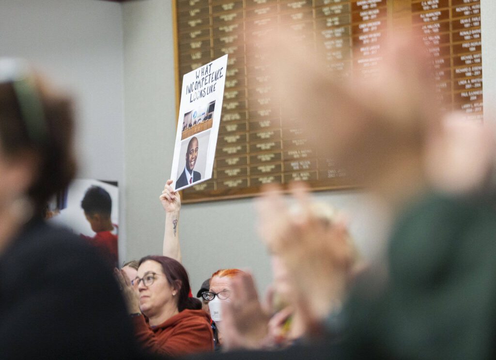 People hold signs during a Marysville School Board meeting on Monday, June 3, 2024, in Marysville, Washington. (Olivia Vanni / The Herald)
