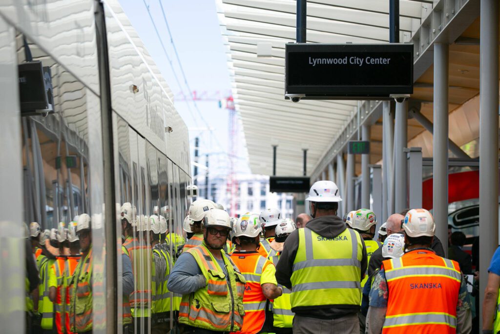 Construction crew members stand together while attending a press event at the Lynnwood City Center Link Station on Friday, June 7, 2024, in Lynnwood, Washington. (Ryan Berry / The Herald)
