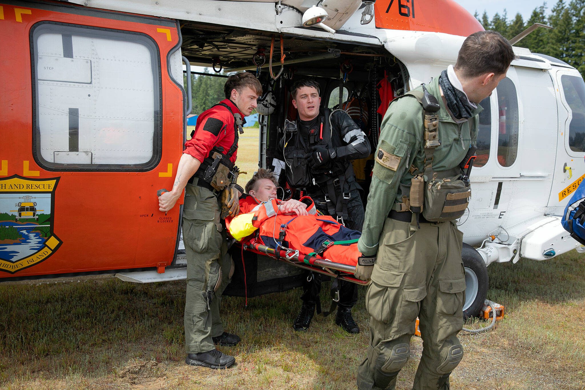 NAS Whidbey Island Search and Rescue members remove a victim from their MH-60 Seahawk to transfer him to a Life Flight Network helicopter during an interagency simulated training session held by Northwest Regional Aviation on Thursday, June 13, 2024, at the Arlington Airport in Arlington, Washington. (Ryan Berry / The Herald)