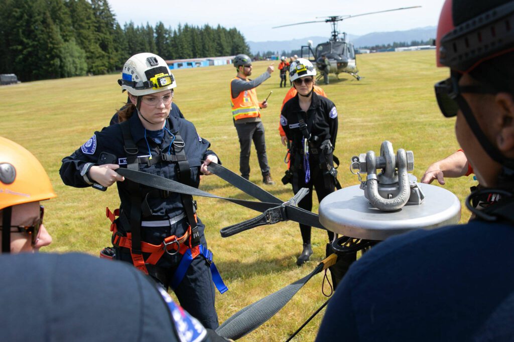Participants take turns learning how to strap into an AirTEP before taking flight in the device during an interagency training session held by Northwest Regional Aviation on Thursday, June 13, 2024, at the Arlington Airport in Arlington, Washington. (Ryan Berry / The Herald)
