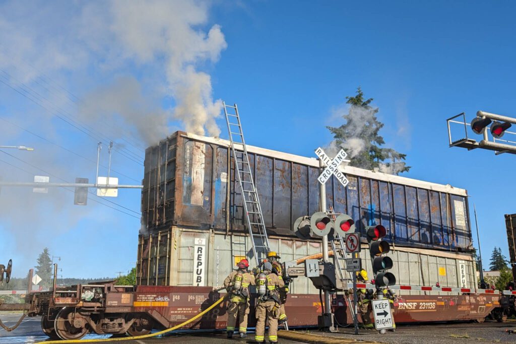 A smoking rail car blocks the intersection at 116th St. NE and State Avenue around 8 a.m. Thursday, June 13, 2024, in Marysville, Washington. (Mike Henneke / The Herald)
