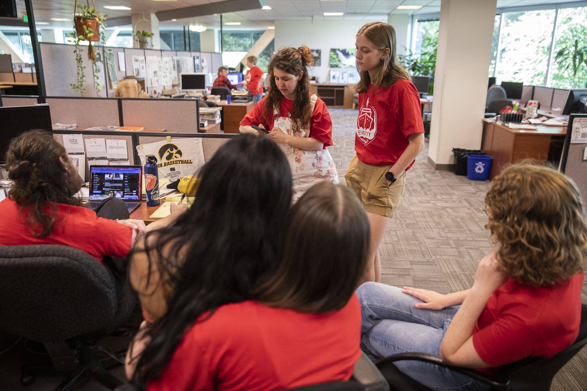 Everett Herald staff gather and talk in the newsroom after layoff announcements on Wednesday, June 19, 2024 in Everett, Washington. (Olivia Vanni / The Herald)