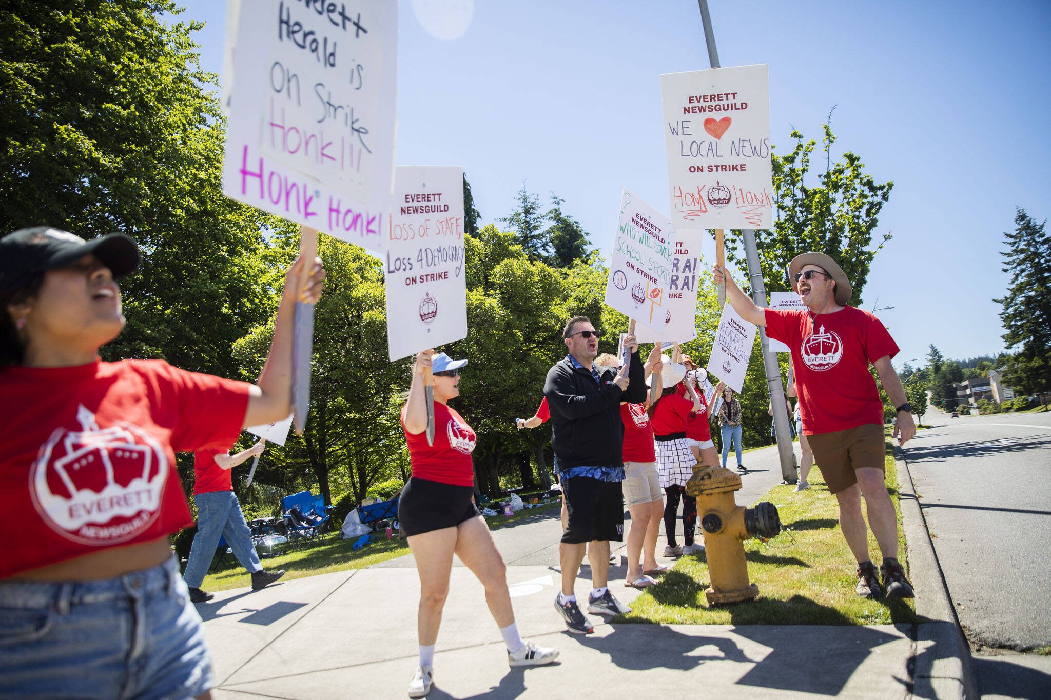 Ryan Berry, right, leads Everett NewGuild members through a chant during the second day of their strike on Tuesday, June 25, 2024 in Everett, Washington. (Olivia Vanni / The Herald)