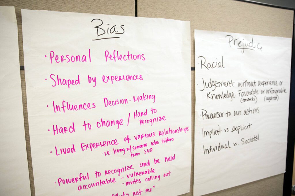 A number of biases are listed on a wall as part of an exercise during a community conversation about opioid use disorder on Thursday, June 27, 2024, at the St. Vincent DePaul Resource Center in Monroe, Washington. (Ryan Berry / The Herald)
