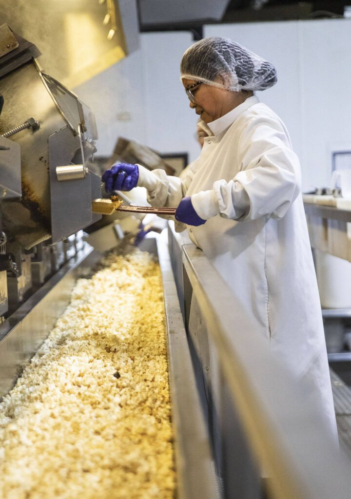 Jaspens employees work on emptying kettles of kettle corn on Tuesday, June 18, 2024 in Monroe, Washington. (Olivia Vanni / The Herald)
