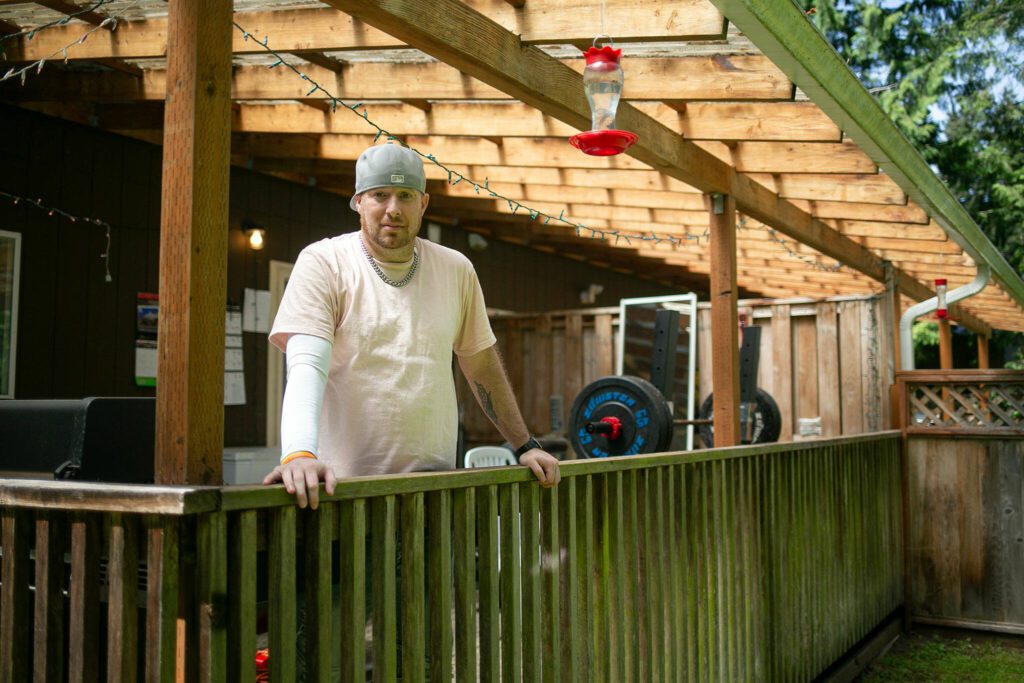 Nick Bollinger, a manager at Hand Up Housing, stands on the back porch of one of the residences on May 31, 2024, in Edmonds, Washington. (Ryan Berry / The Herald)
