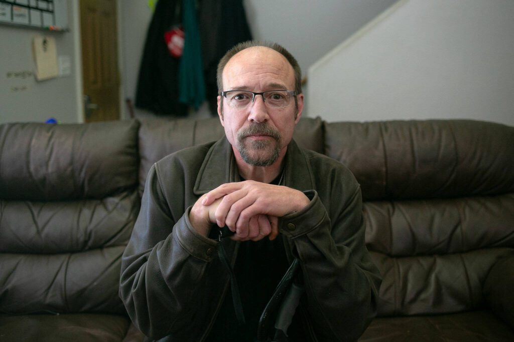 John Jacobs, 58, sits inside at a Hand Up Housing residence on May 31, 2024, in Edmonds, Washington. (Ryan Berry / The Herald)
