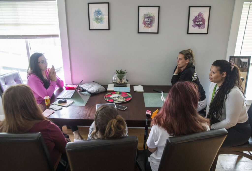 Sarah Aburto, left, talks through house chores and other items with residents.

