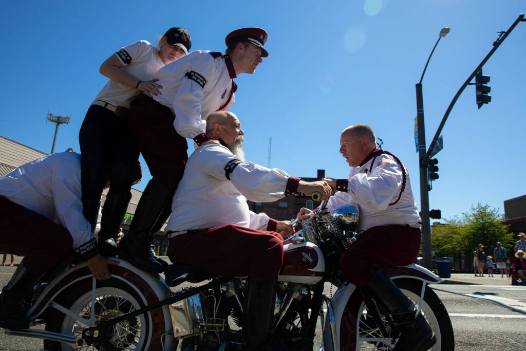 The Seattle Cossacks Motorcycle Stunt Team pile onto a motorcycle during Everett’s Fourth of July Parade on Thursday, July 4, 2024, in downtown Everett, Washington. (Ryan Berry / The Herald)
