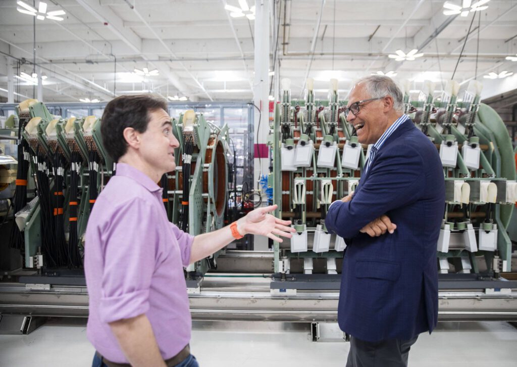 Gov. Jay Inslee laughs while talking with Helion Energy CEO and co-founder David Kirtley on Tuesday, July 9, 2024, in Everett, Washington. (Olivia Vanni / The Herald)
