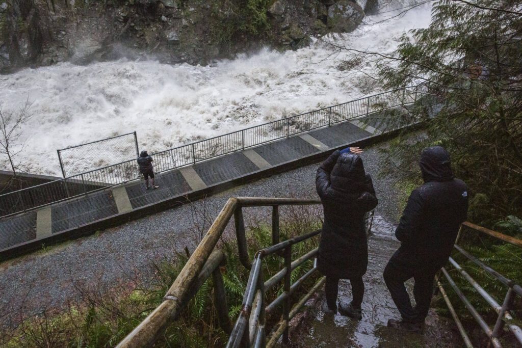 People pause on the stairs to look at the water rushing through the Granite Falls Fish Ladder on Saturday, Feb. 1, 2020 in Granite Falls, Washington. (Olivia Vanni / The Herald)
