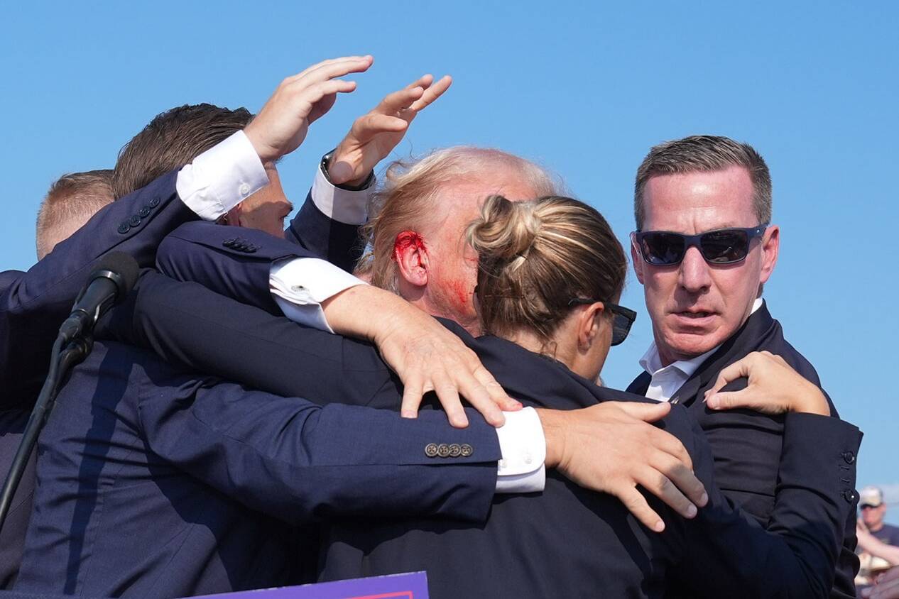 Former president Donald Trump is seen with a bloody ear as he is assisted off the stage during a campaign rally in Butler, Pa., on Saturday. MUST CREDIT: Jabin Botsford/The Washington Post
