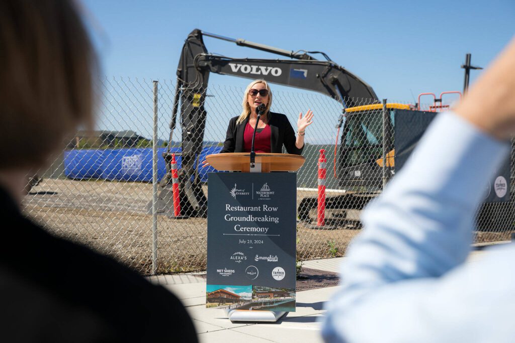 Port of Everett CEO Lisa Lefeber addresses a sizable gathering of people at a groundbreaking ceremony for Restaurant Row at the Port of Everett on Tuesday, July 23, 2024, in Everett, Washington. (Ryan Berry / The Herald)
