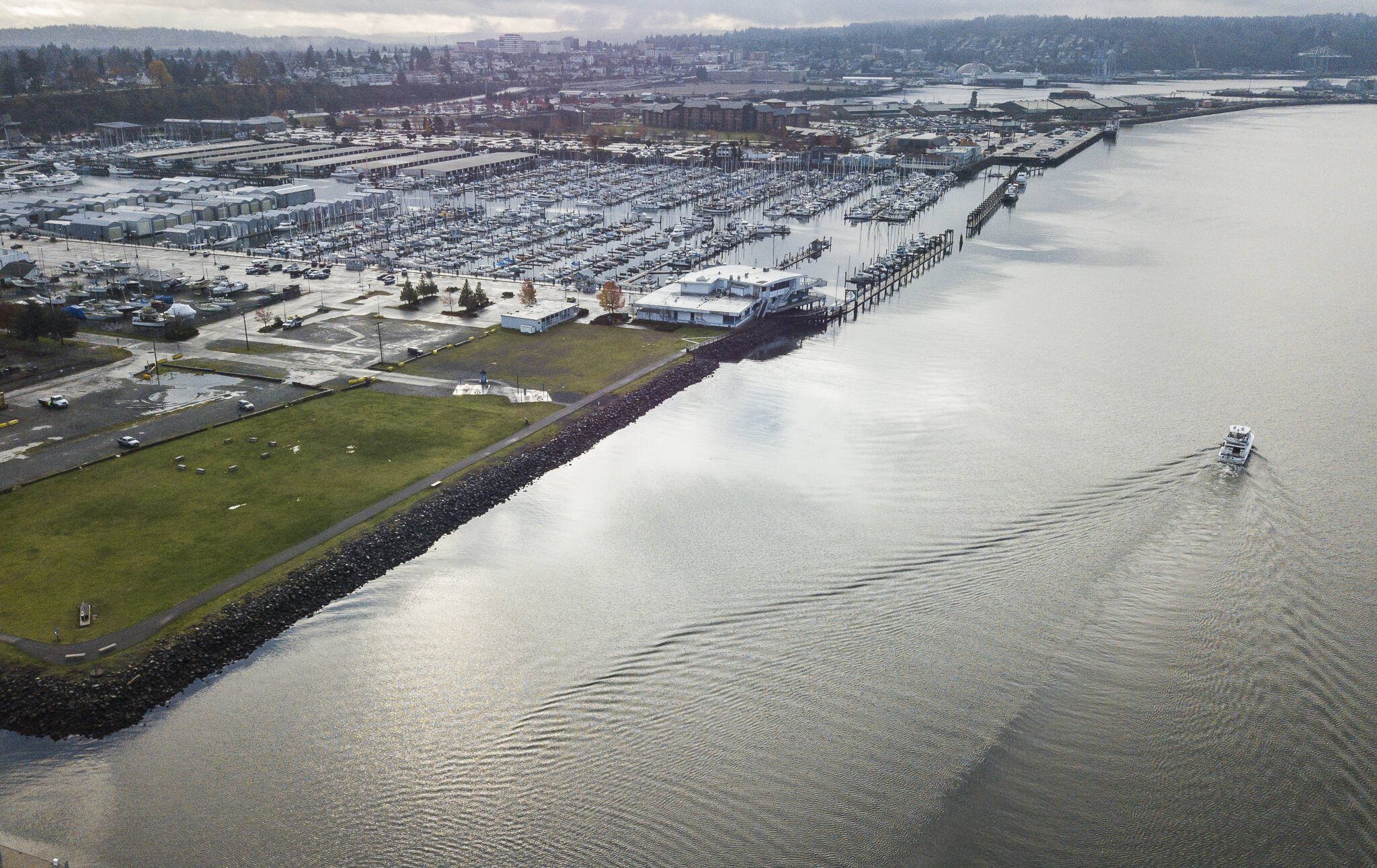 A boat drives out of the Port of Everett Marina in front of Boxcar Park, which is one of the sites set to be elevated in preparation for rising sea levels on Nov. 25, 2020, in Everett, Washington. (Olivia Vanni / The Herald)