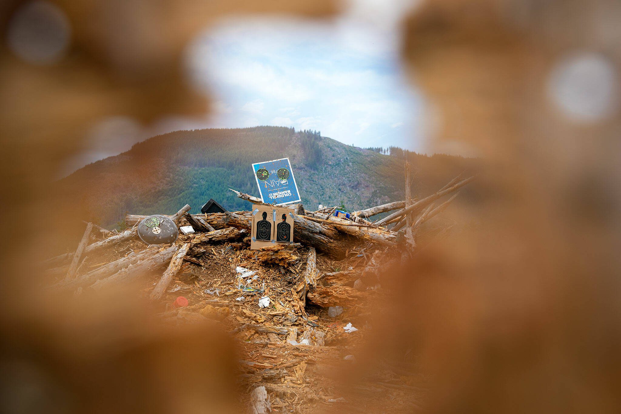 Targets and an assortment of trash and debris are mounded into a backstop at an unofficial shooting range along Green Mountain Road on Wednesday, July 17, 2024, near Granite Falls, Washington. Shell casings and trash are scattered along the road as well as throughout the clearcut area. (Ryan Berry / The Herald)