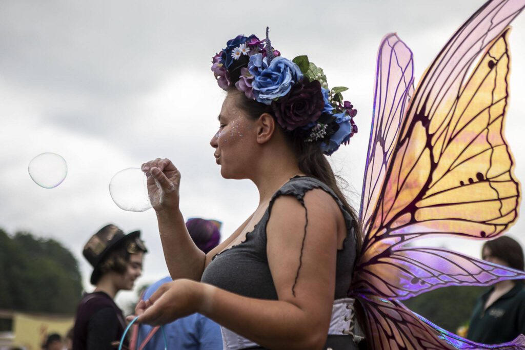 An individual blows bubbles using their hand as a wand during the Washington Midsummer Renaissance Faire at Sky Meadows Park in Snohomish, Washington, on Sunday, Aug. 06, 2023. (Annie Barker / The Herald)
