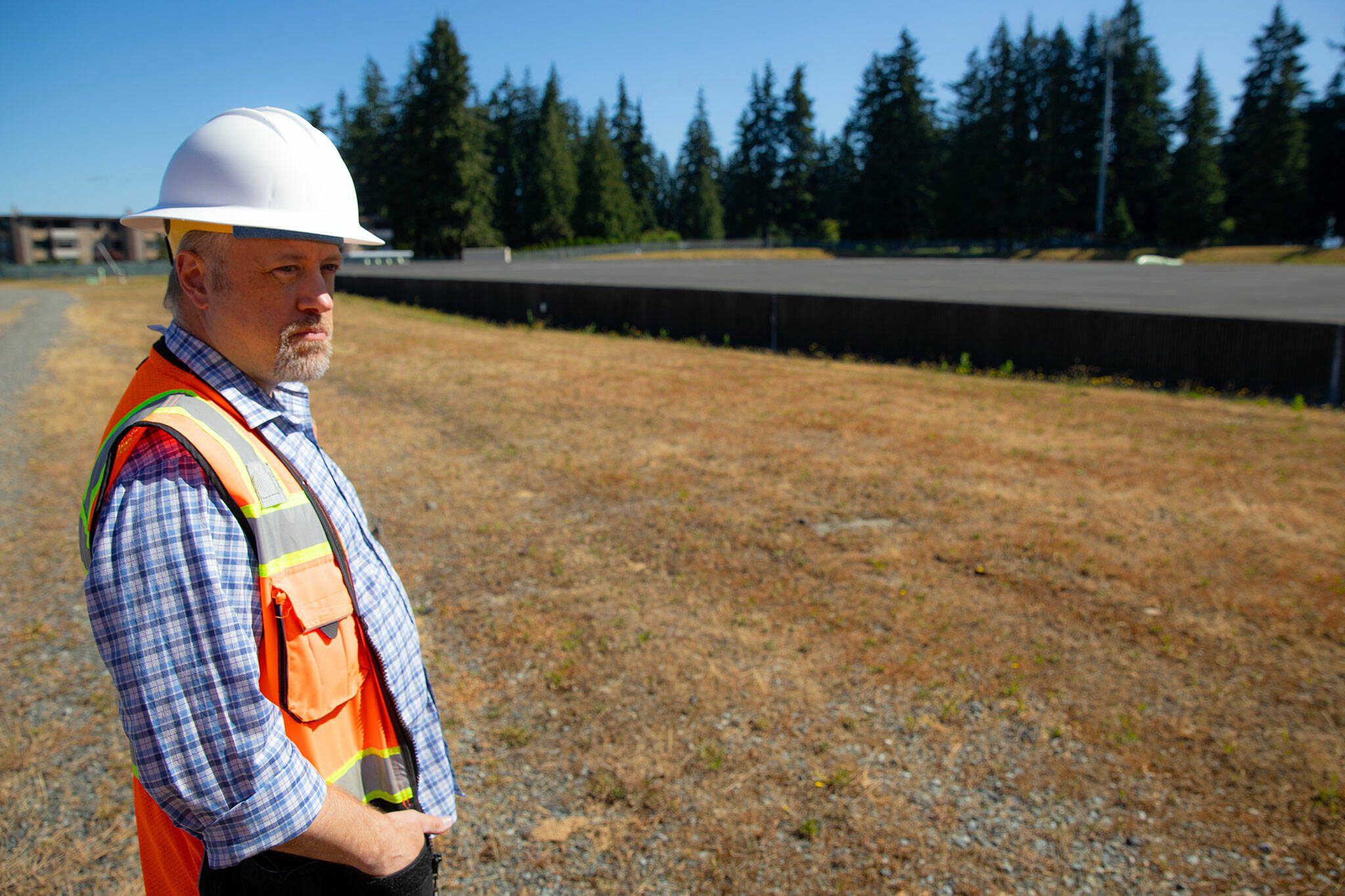 Public Works Senior Engineer Randy Loveless looks out over Everett’s 101-year-old reservoir at a groundbreaking ceremony for the Reservoir 3 Replacement Project on Tuesday, July 23, 2024, in Everett, Washington. (Ryan Berry / The Herald)