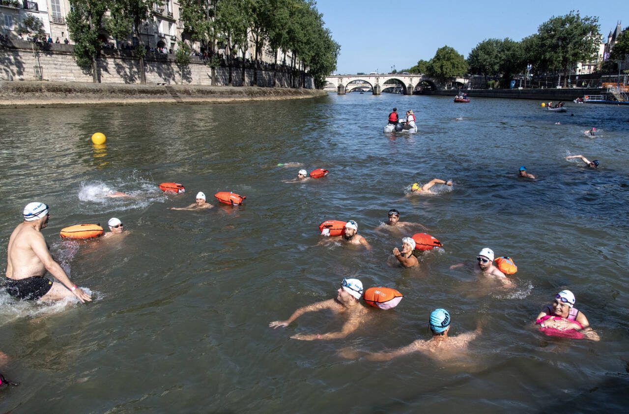 Swimmers in the Seine join a swim by Parisian Mayor Anne Hidalgo and Tony Estanguet, head of the Paris Olympics committee, to prove the river’s worth for swimming events, in Paris, July 17. As a heat wave continues through much of Europe, swimmers may be a few of the Olympic athletes staying cool. (James Hill / The New York Times)