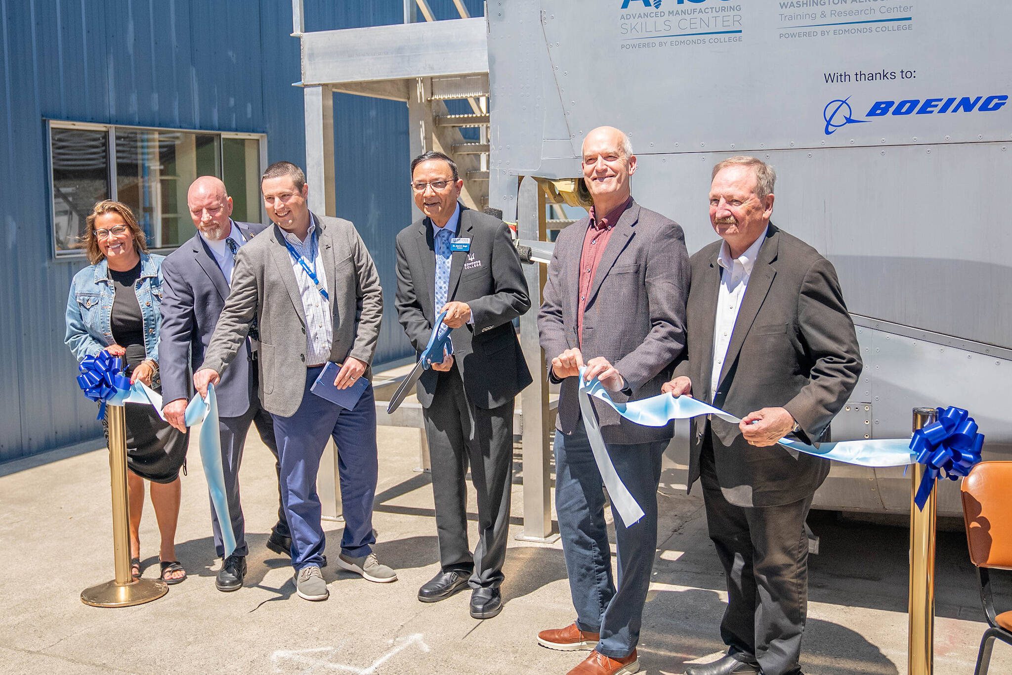 Everett Mayor Cassie Franklin, Advanced Manufacturing Skills Center executive director Larry Cluphf, Boeing director of manufacturing and safety Cameron Myers, Edmonds College President Amit Singh, U.S. Rep. Rick Larsen, and Snohomish County Executive Dave Somers participate in a ribbon-cutting ceremony on July 2 celebrating the opening of a new fuselage training lab at Paine Field.(Arutyun Sargsyan / Edmonds College)