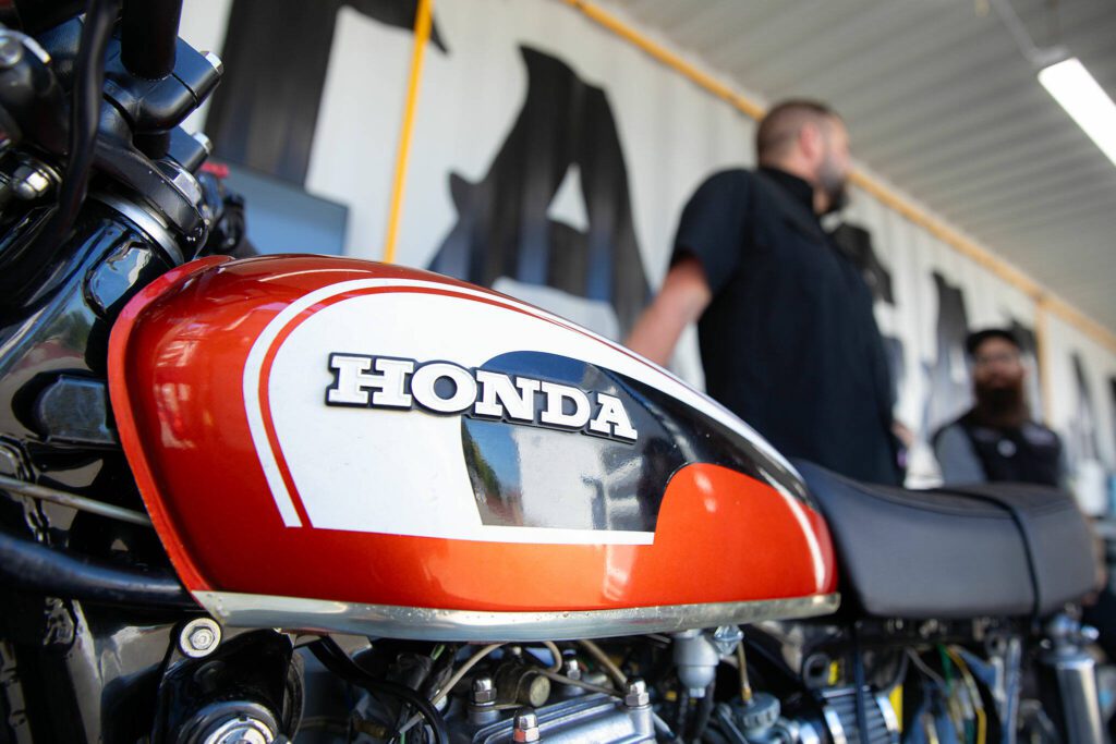 Luke Emerson and Jared Kalinski stand next to Emerson’s Honda CB175 at Delta Garage on July 5 in Everett. (Ryan Berry / The Herald)
