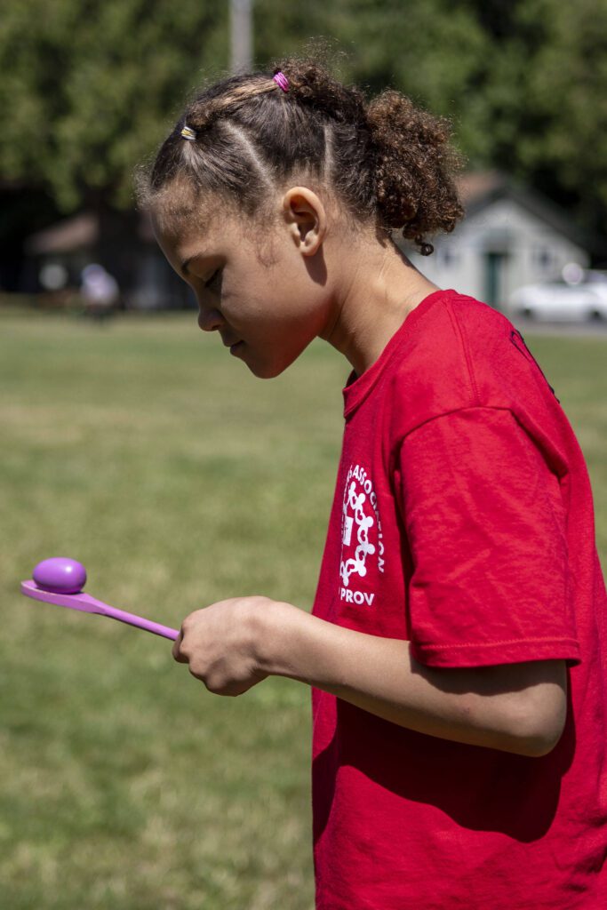 Amilya “Mi Mi” Plakio, 10, balances a wooden egg on a spoon for an obstacle course during Camp Prov at Forest Park in Everett, Washington on Wednesday, July 24, 2024. (Annie Barker / The Herald)x
