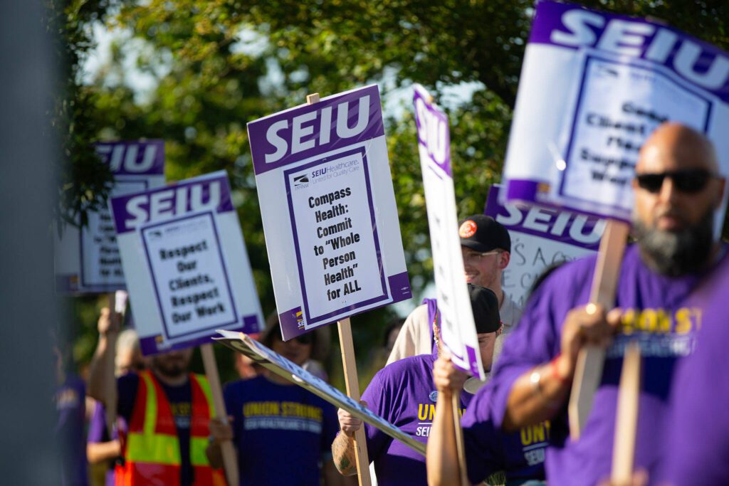 Unionized Compass Health workers picket in front of the Compass Evaluation and Treatment building on Thursday, Aug. 1, 2024, in Mukilteo, Washington.
