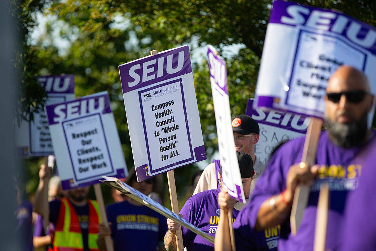 Unionized Compass Health workers picket in front of the Compass Evaluation and Treatment building on Thursday, Aug. 1, 2024, in Mukilteo, Washington. (Ryan Berry / The Herald)