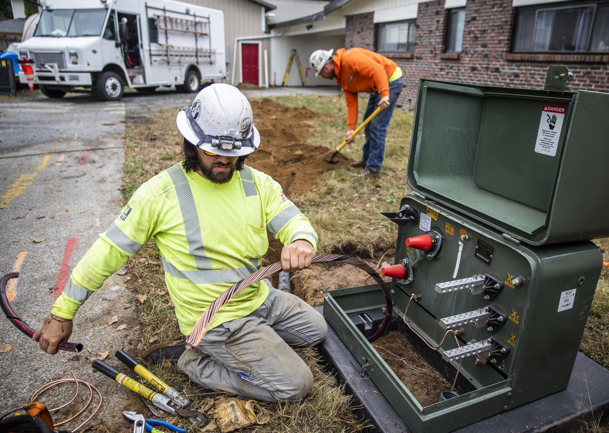 Cole Riccardo works on setting up new underground power lines on Thursday, Aug. 31, 2023 in Arlington, Washington.