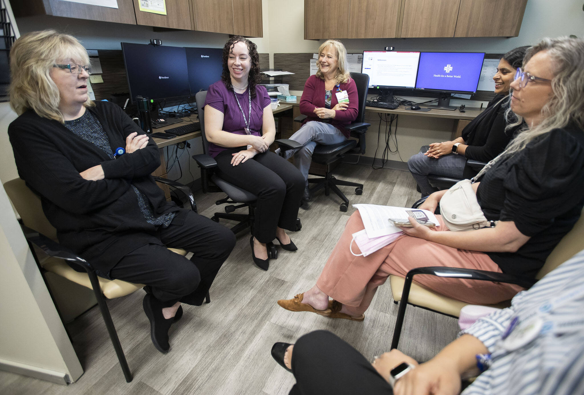 Providence Behavioral Health Urgent Care employees chat after a short training presentation on Wednesday, Aug. 21, 2024 in Everett, Washington. (Olivia Vanni / The Herald)