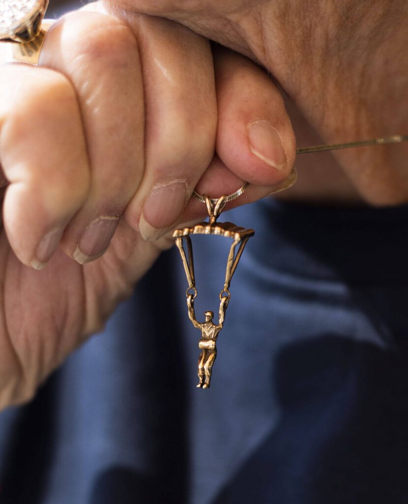 Kim Knor holds up a hold skydiver necklace charm that she wears on Wednesday, Aug. 14, 2024 in Snohomish, Washington. (Olivia Vanni / The Herald)
