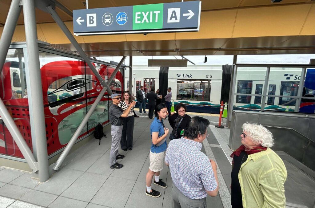 Media, government employees and artists stand at the Lynnwood light rail platform on Tuesday. (Jordan Hansen / The Herald)
