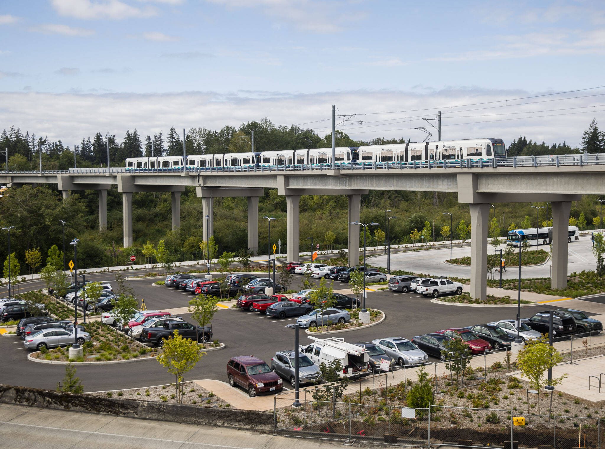 A Link train passes over a parking lot south of the Lynnwood City Center Station on Monday, Aug. 12, 2024 in Lynnwood, Washington. (Olivia Vanni / The Herald)