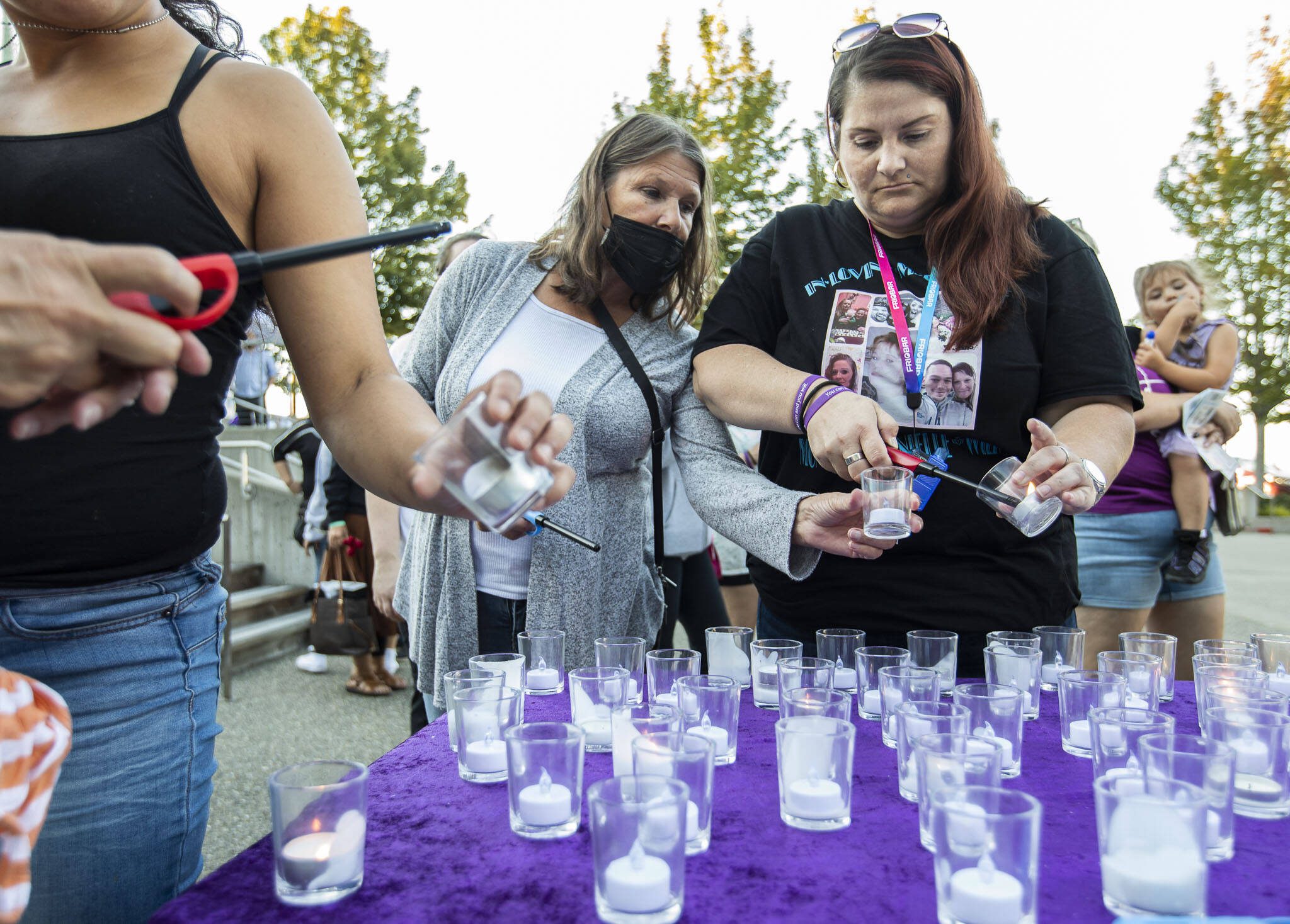 Christina Cratty, right, and her mother Storm Diamond, left, light a candle for their family member Monique (Mo) Wier who died from an overdose last July during A Night to Remember, A Time to Act opioid awareness event at the Snohomish County Campus on Thursday, Aug. 29, 2024 in Everett, Washington. (Olivia Vanni / The Herald)