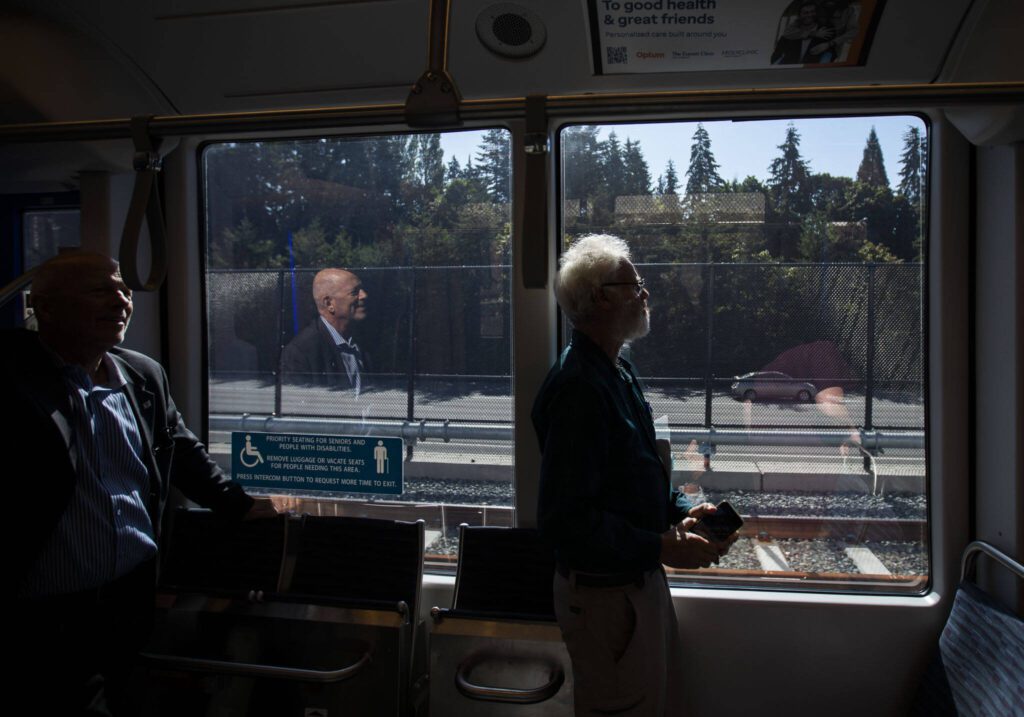 People are illuminated by sunlight as they ride the Link light rail on Wednesday, Aug. 28, 2024 in Mountlake Terrace, Washington. (Olivia Vanni / The Herald)
