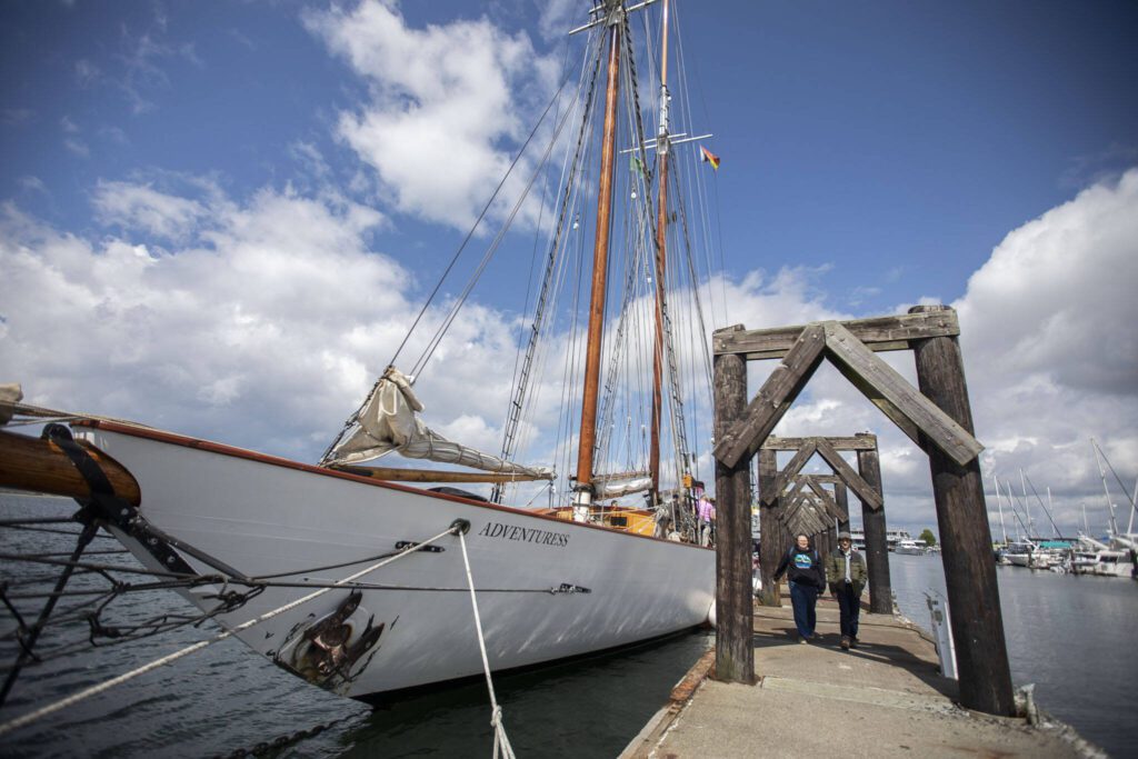 People walk by the Adventuress docked at the Port of Everett on Tuesday, Aug. 27, 2024 in Everett, Washington. (Olivia Vanni / The Herald)
