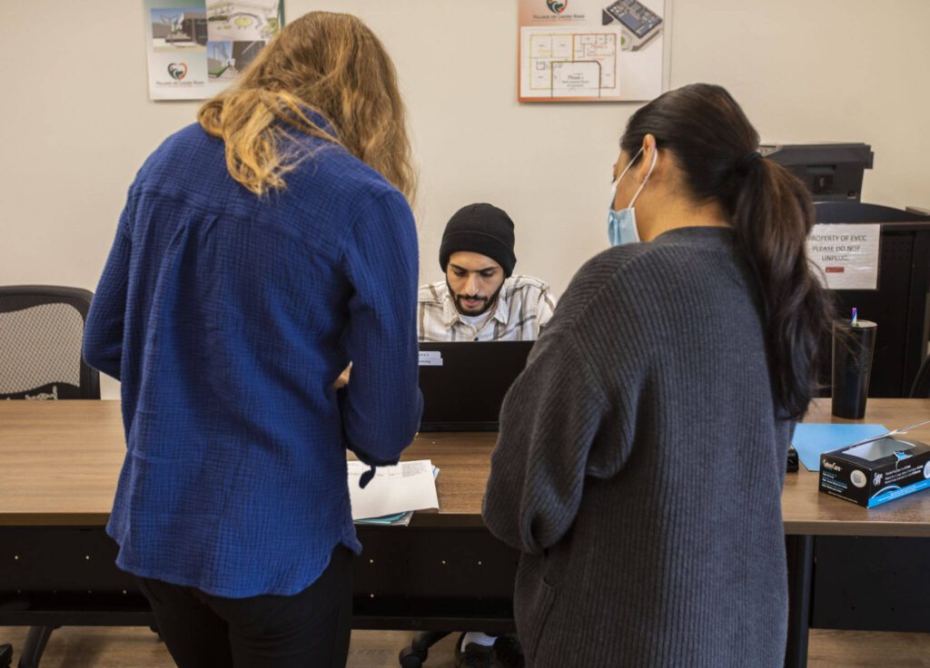 Volunteers help people schedule and check-in for appointments at The Village on Casino Road on Friday, Sept. 20, 2024 in Everett, Washington. (Olivia Vanni / The Herald)
