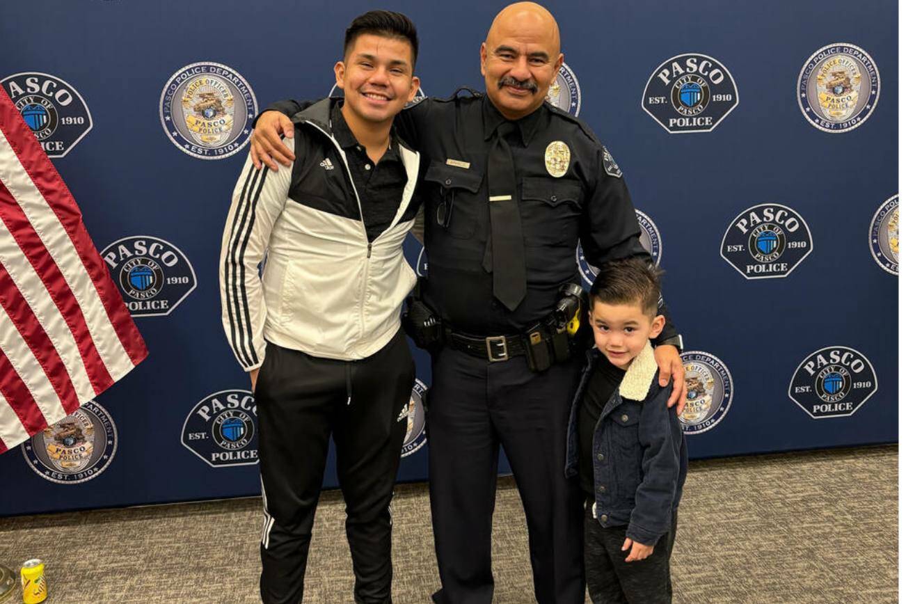 Victor Manuel Arzate poses with his son and retired officer Raymond Aparicio, who mentored Arzate growing up. (Mary Murphy for Cascade PBS)