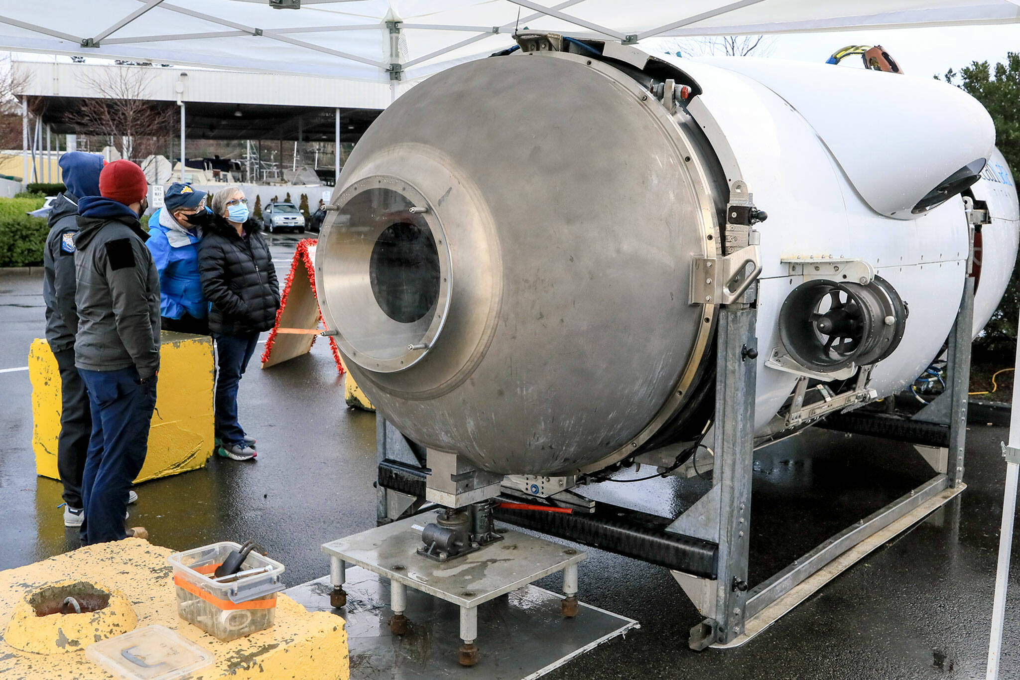 Ryan Stalkfleet, left to right, and Kenny Hauge, members of the OceanGate submersible crew, explains the vehicles features and operations to Bill McFerren and Kiely McFerren Thursday afternoon at the Port of Everett on December 16, 2021. (Kevin Clark / The Herald)
