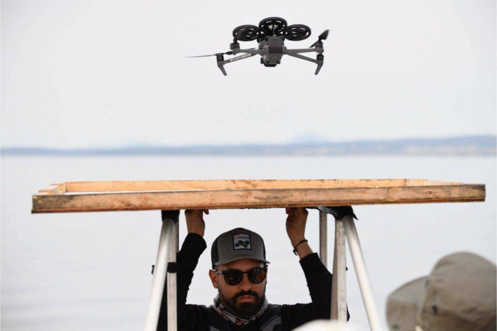 San Diego Zoo Alliance UAV pilot holds a landing pad while a drone lands after collecting breath samples. (Provided photo)
