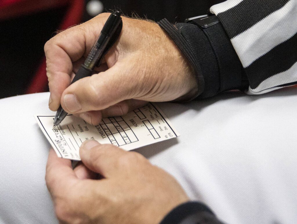 Dean Corcoran fills out part of a game card in the locker room before the start of the game on Friday, Oct. 4, 2024 in Snohomish, Washington. (Olivia Vanni / The Herald)
