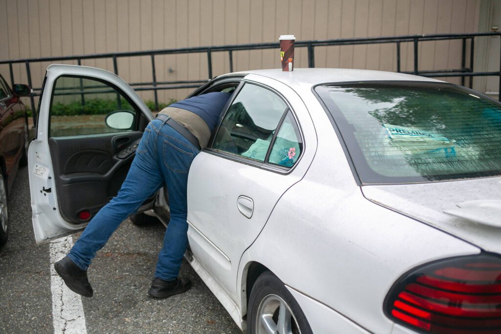 George Beard grabs something from his car while parked at the Stanwood Library on May 23. (Ryan Berry / The Herald)
