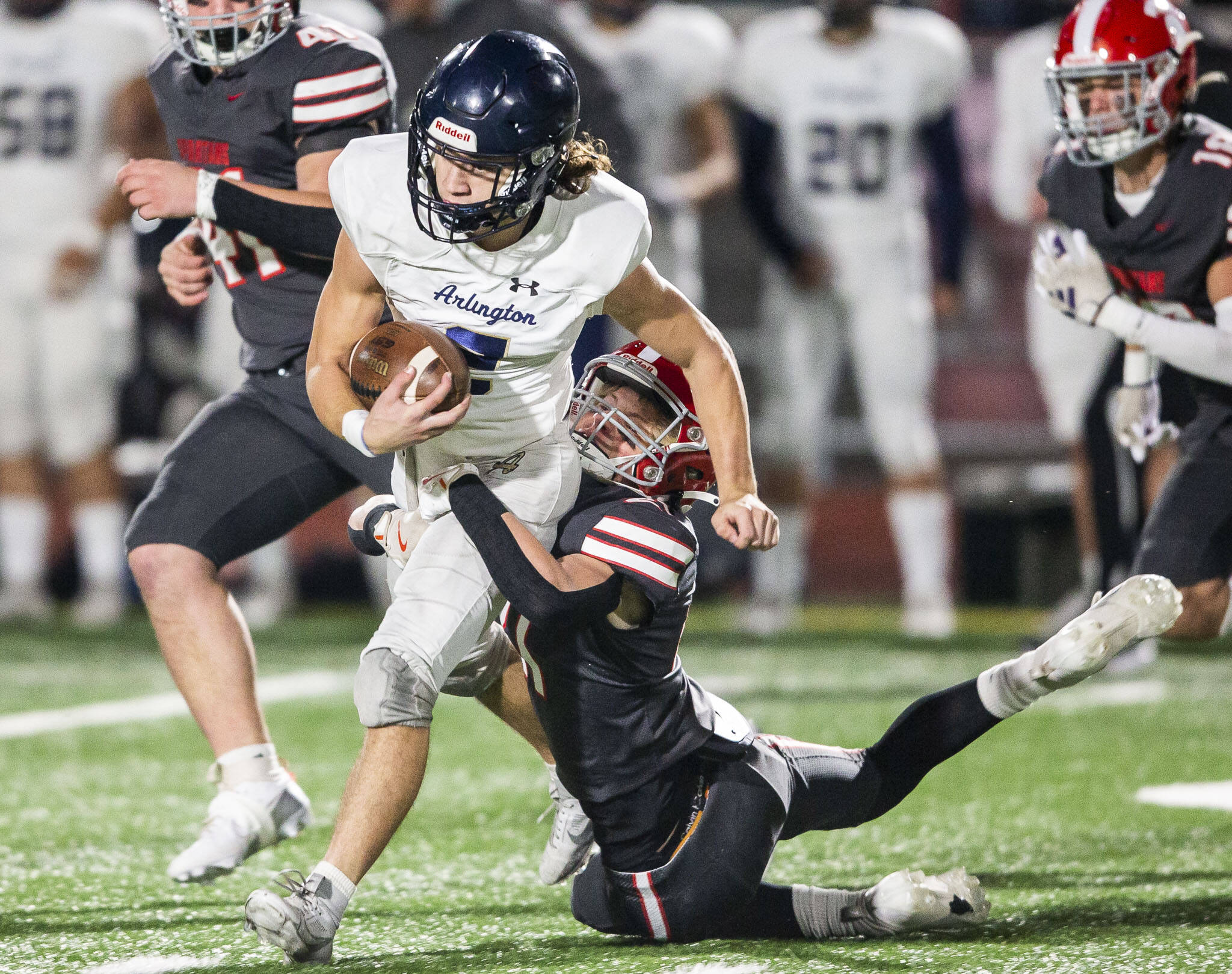Arlington’s Chase Deberry runs through a tackle by during the game on Friday, Oct. 11, 2024 in Stanwood, Washington. (Olivia Vanni / The Herald)