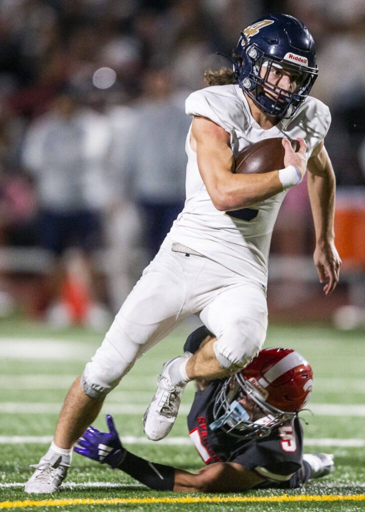 Arlington’s Chase Deberry escapes a tackle by Stanwood’s Canyon Bumgarner during the Stilly Cup game on Friday, Oct. 11, 2024 in Stanwood, Washington. (Olivia Vanni / The Herald)
