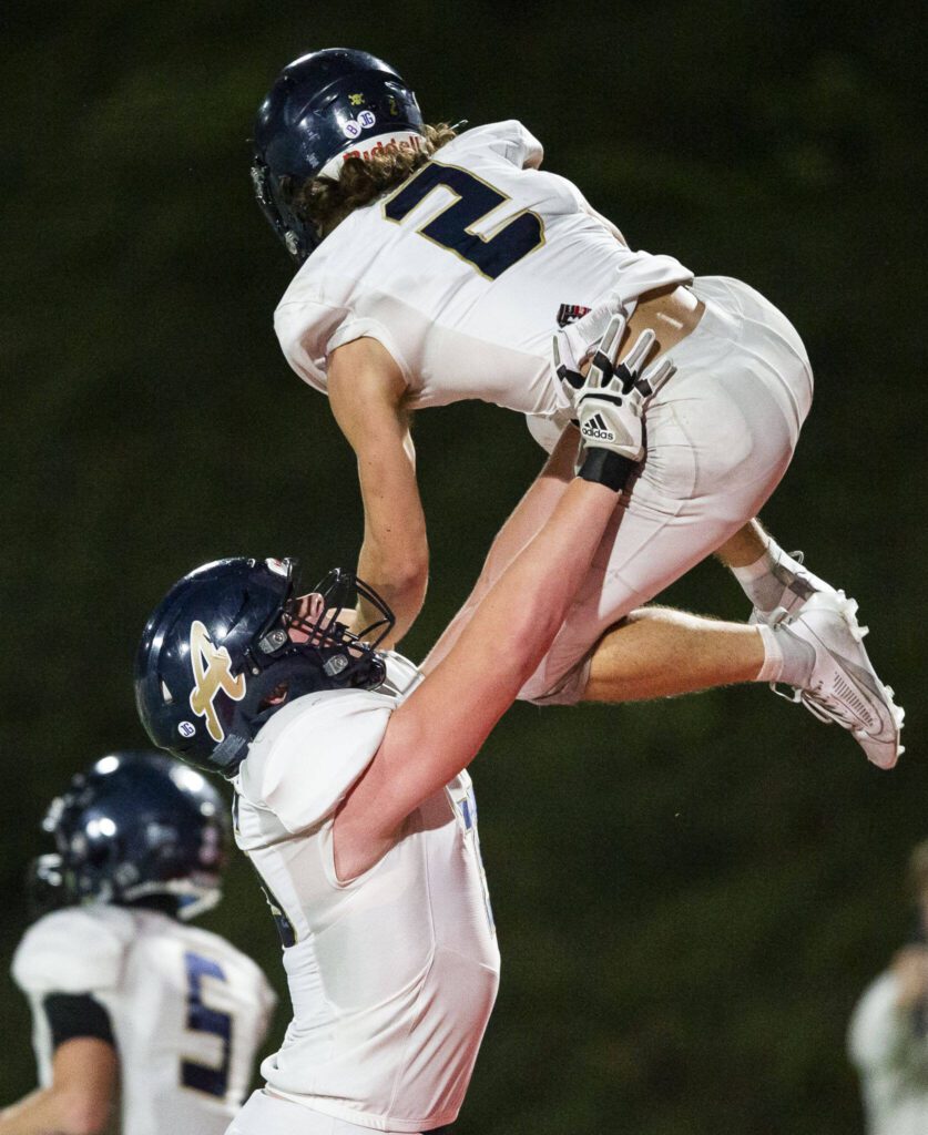 Arlington’s Chase Deberry is lifted in the air to celebrate his touchdown during the Stilly Cup game against Stanwood on Friday, Oct. 11, 2024 in Stanwood, Washington. (Olivia Vanni / The Herald)

