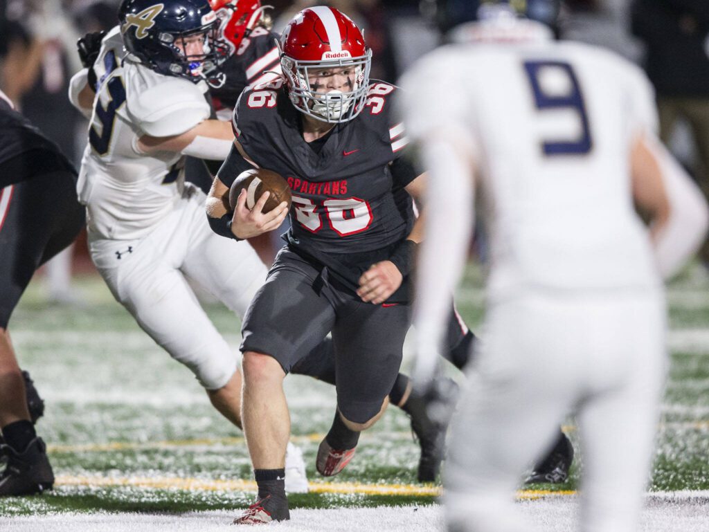 Stanwood’s Eben Bland Jr runs the ball during the Stilly Cup game against Arlington on Friday, Oct. 11, 2024 in Stanwood, Washington. (Olivia Vanni / The Herald)

