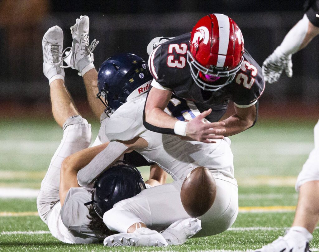 A tackle by Arlington’s Kaid Hunter causes Stanwood’s Ethan Burke to the fumble the ball resulting in a turnover during the Stilly Cup game on Friday, Oct. 11, 2024 in Stanwood, Washington. (Olivia Vanni / The Herald)
