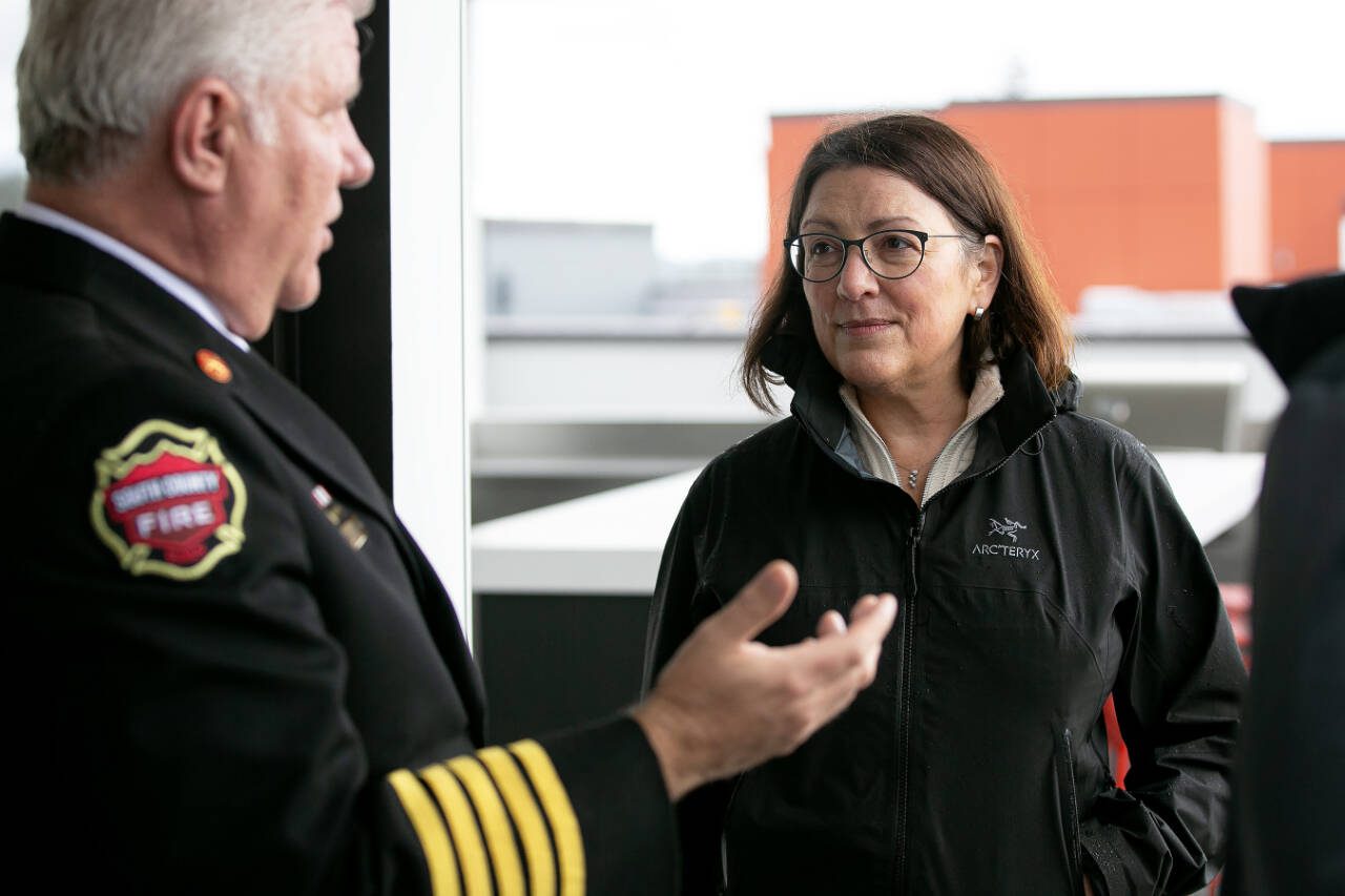 Rep. Suzan DelBene, D-Wash., and South County Fire Chief Bob Eastman chat during a tour and discussion with community leaders regarding the Mountlake Terrace Main Street Revitalization project, May 28, at the Traxx Apartments in Mountlake Terrace. (Ryan Berry / The Herald file photo)
